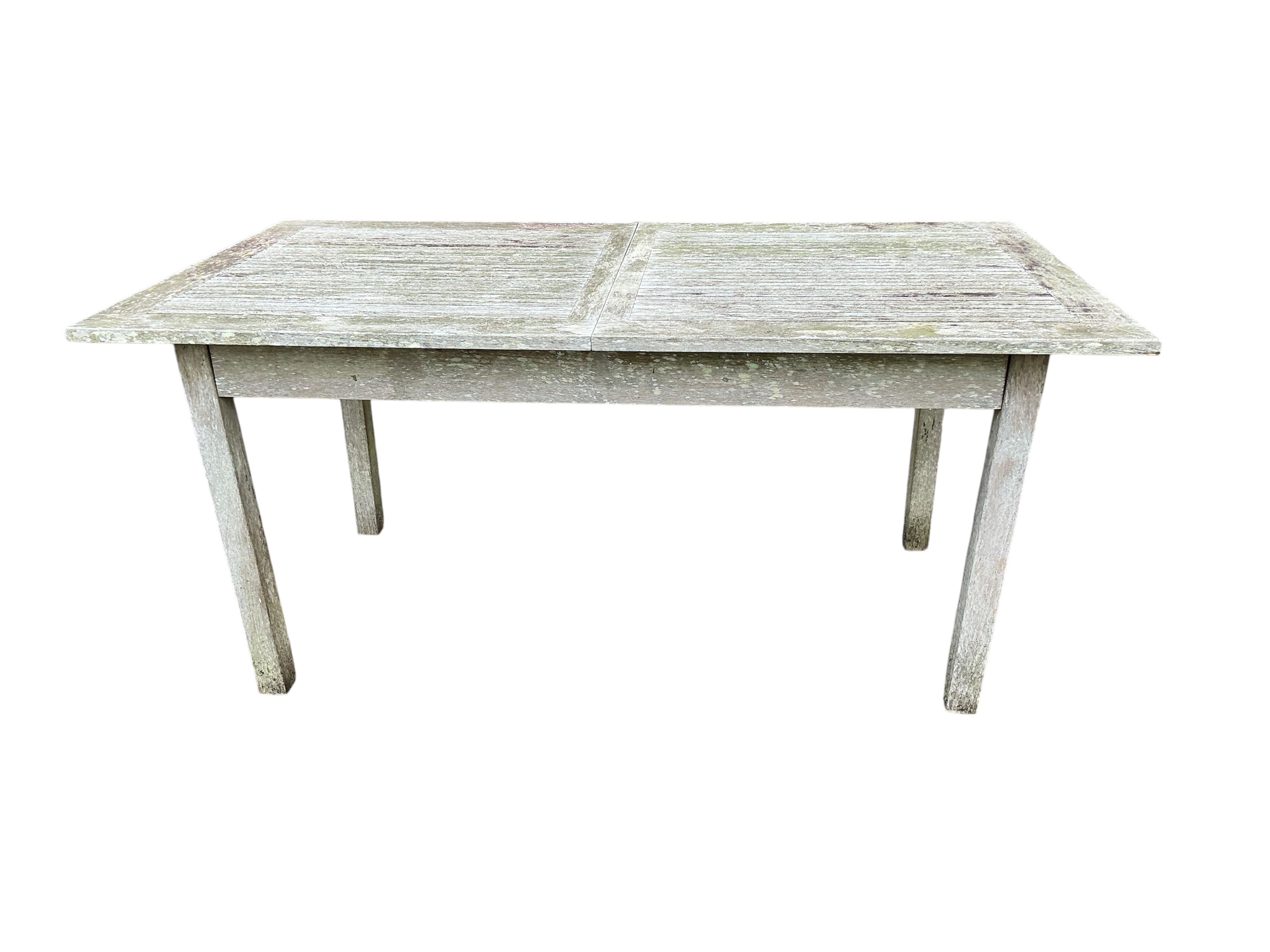 An Indian Ocean Trading Company rectangular teak extending garden table, width 164cm, depth 90cm, height 74cm, four folding chairs and a canvas parasol with metal stand